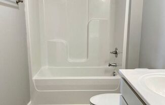 a bathroom with a toilet and a tub and a sink