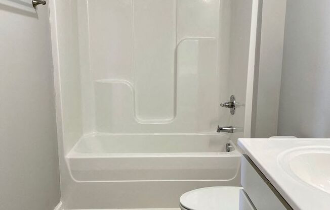 a bathroom with a toilet and a tub and a sink