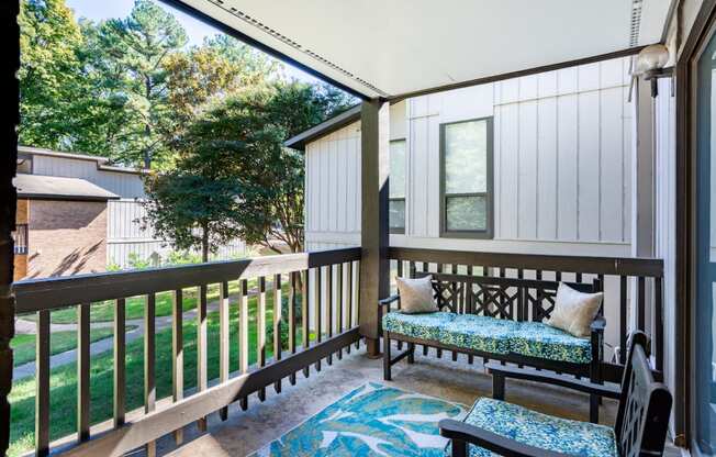 a covered porch with a bench and a window