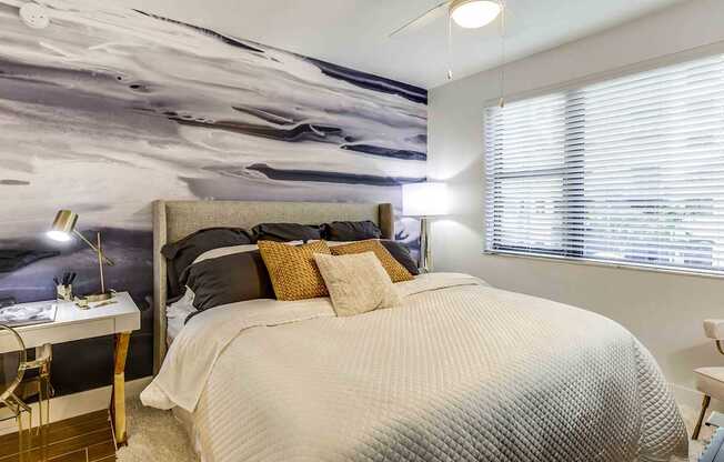 A bedroom with a large bed and a wall mural.