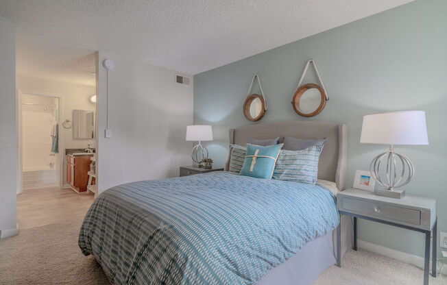 a bedroom with a bed and lamps and a mirror at City View Apartments at Warner Center, Woodland Hills, CA