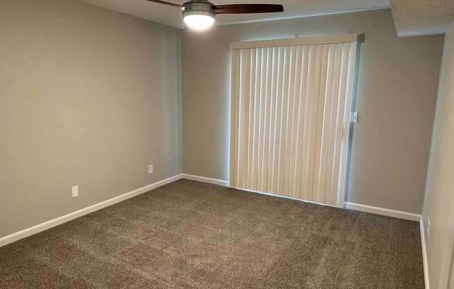 a bedroom with a sliding door and a ceiling fan