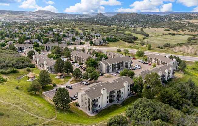 A large building complex with a parking lot in front of it.
