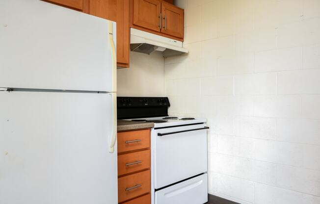 an empty kitchen with a white refrigerator and stove