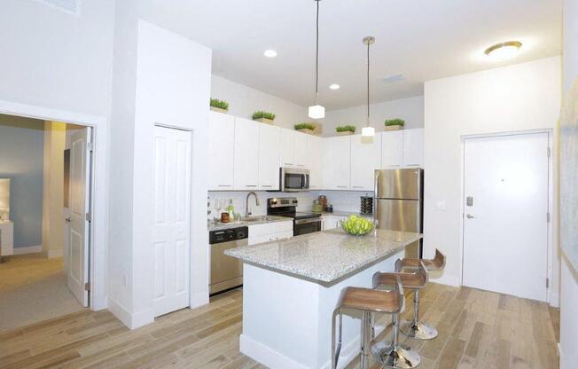 a kitchen with an island and a stainless steel refrigerator