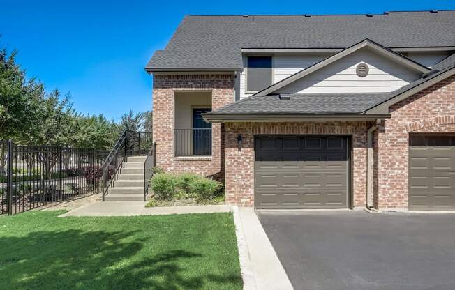 a house with a driveway and a garage door in front of it  at The Vista on Brodie, Austin, TX