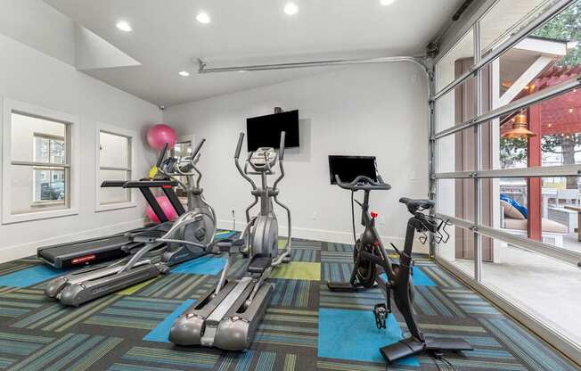 A room with exercise equipment and a TV.