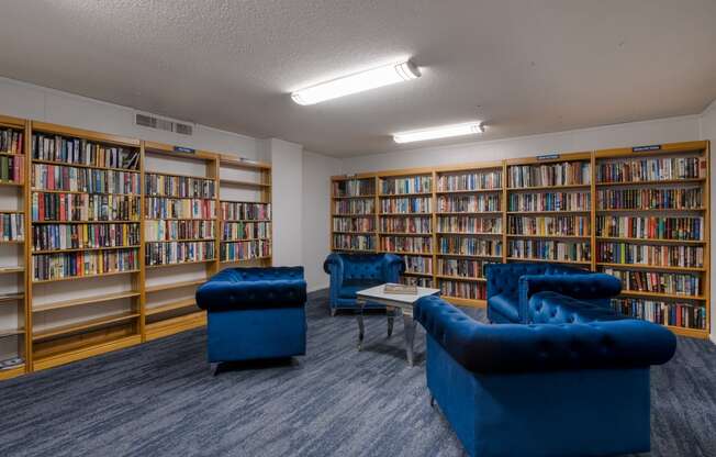 a library with blue chairs and bookshelves