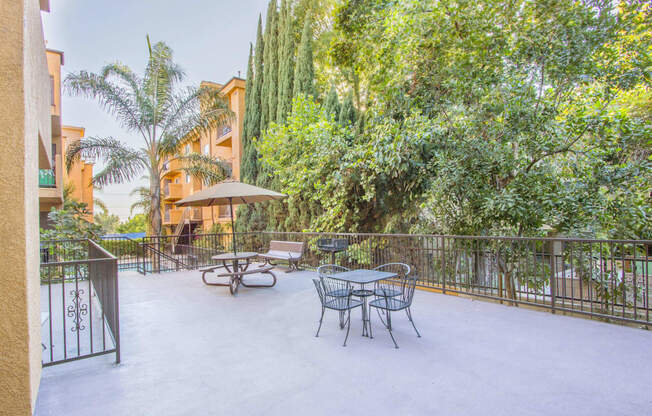 a patio with a table and chairs and a fence at Dronfield Astoria Apartments, CA, 91342