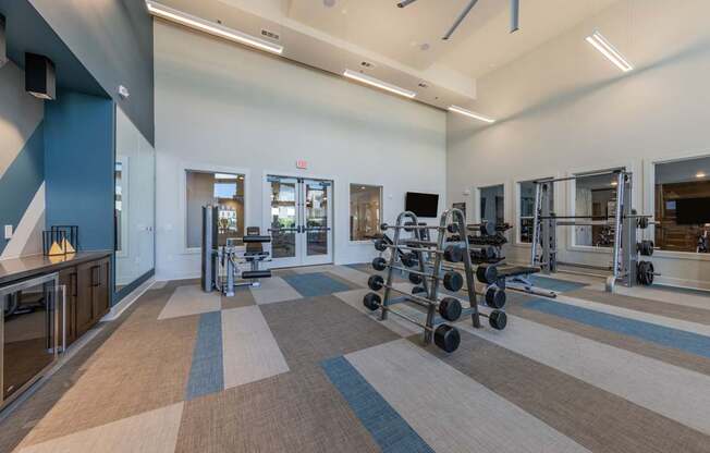 A gym with a variety of equipment including weights and treadmills.
