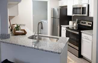 an open kitchen with granite counter top and stainless steel appliances at Twenty35 at Timothy Woods, Athens, GA