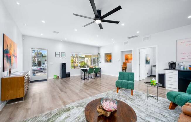 A modern living room with a wooden coffee table and green chairs.