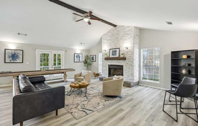 an open living room with a fireplace and a ceiling fan