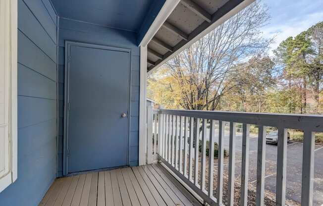the view from the deck of a blue house with a blue door and a balcony