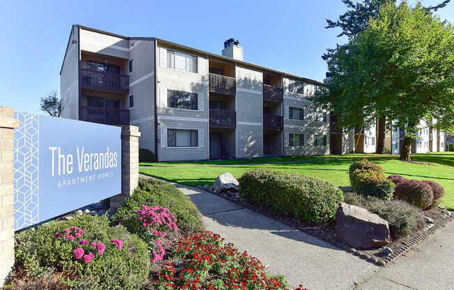 The Verandas Apartment Homes building with a blue sign in front of it.