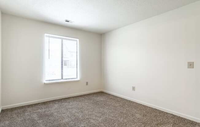 an empty room with carpet and a window at Pheasant Run in Lafayette, IN 47909