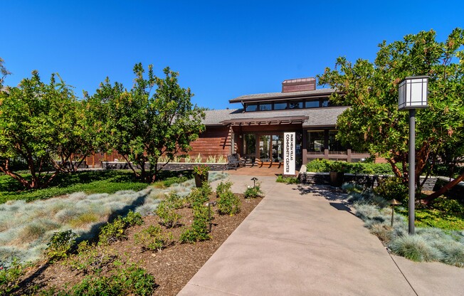 A building with a brown roof and a white sign in front of it.