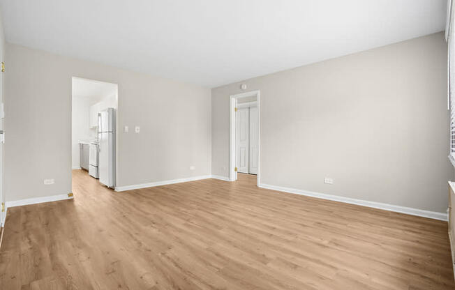 A room with wooden flooring and white walls.