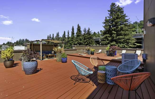 a roof deck with chairs and potted plants at Illumina Apartment Homes, Seattle, 98102
