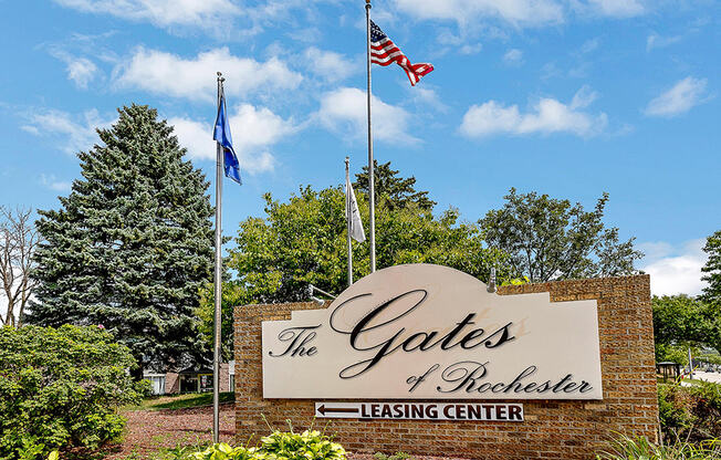 a sign for the gates of excellence leasing center flags