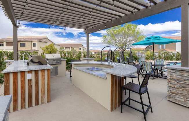 A patio with a hot tub and chairs under a roof.