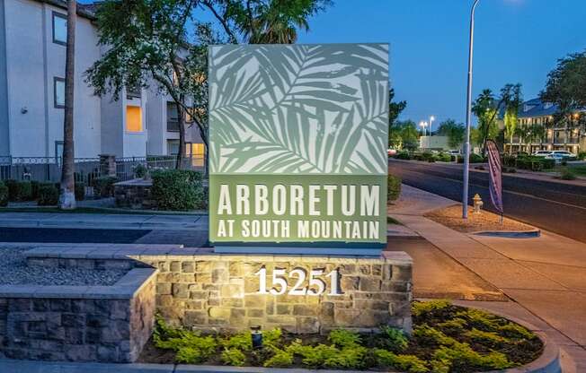 A sign for Arboretum at South Mountain stands in front of a building.