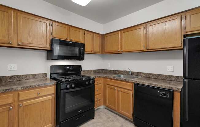 a kitchen with black appliances and wooden cabinets