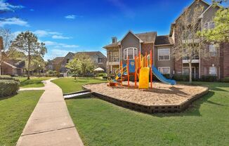 an empty playground in the middle of an apartment complex