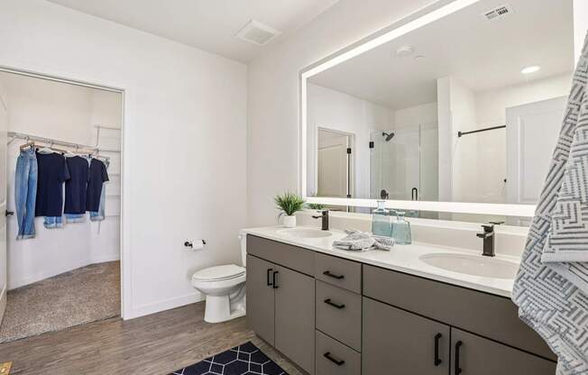 A bathroom with a white toilet, a sink, and a mirror.