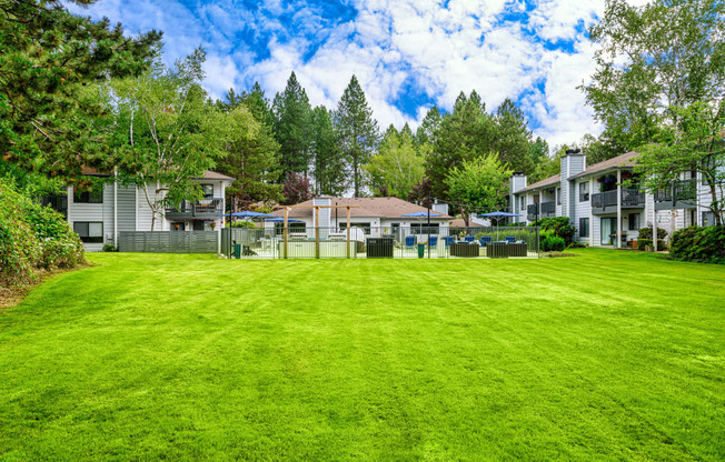 a large grassy area with houses in the background