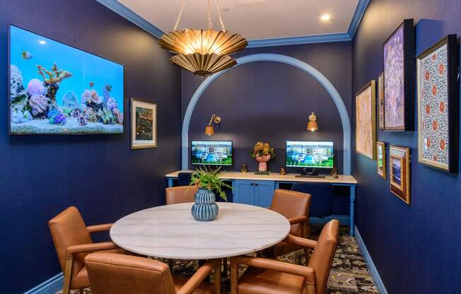 A room with a round table and chairs, a television, and a chandelier.