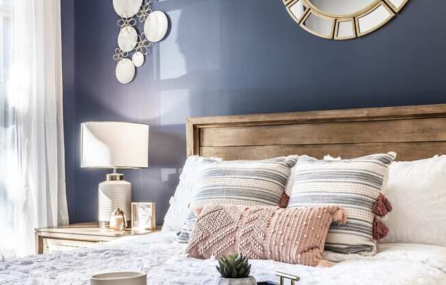a bedroom with a blue wall and a bed with a wooden headboard and white bedding
