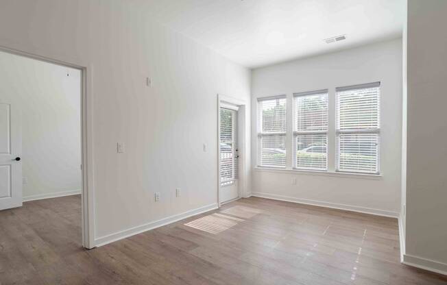 an empty living room with white walls and wood floors