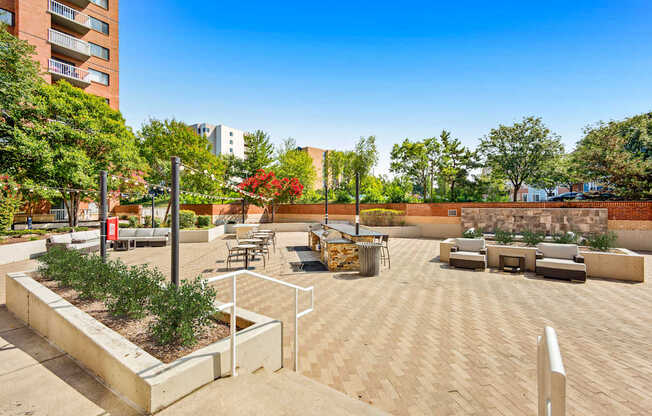 A courtyard with a bench, a table, and a planter box.