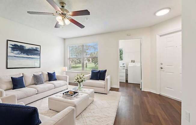 A living room with a white couch and a ceiling fan.