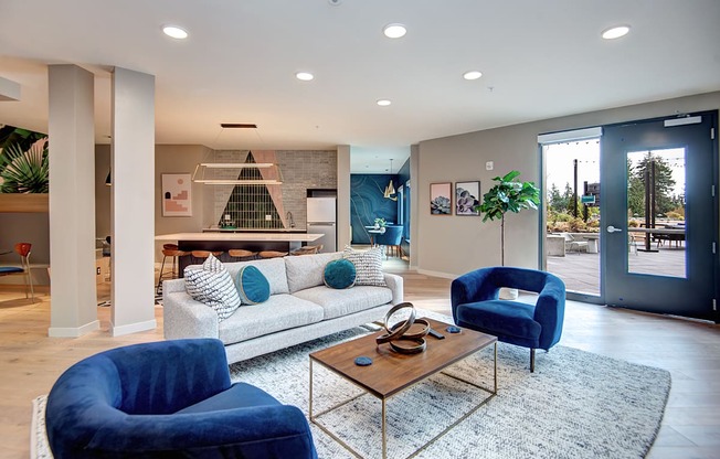 a living room with blue chairs and a couch at Hazel Apartments, Washington, 98026