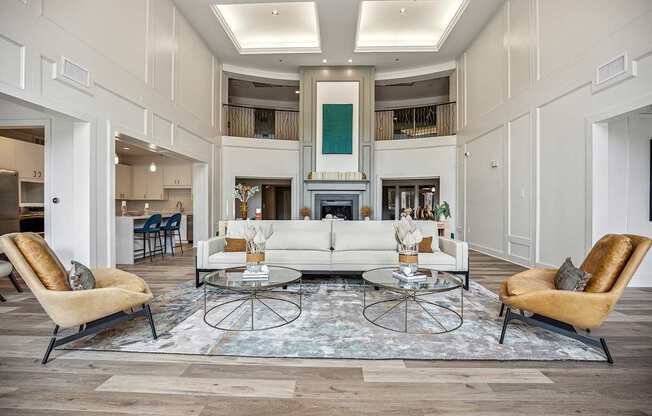 A living room with a white sofa and two chairs.