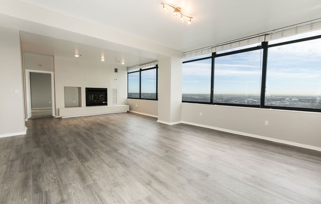 the living room of an apartment with a large window overlooking the city at Apartments at Denver Place, Denver, CO