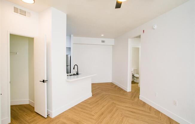 an empty room with a ceiling fan and hardwood floors