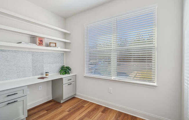 A kitchen with a window and a plant on the counter.