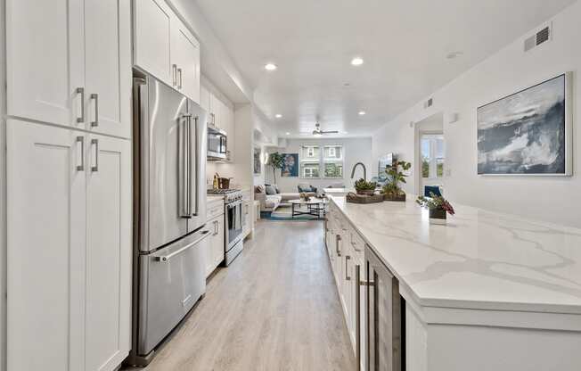 a large white kitchen with white cabinets and stainless steel appliances