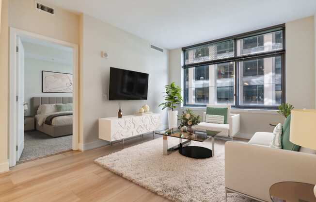 a living room with white furniture and a large window