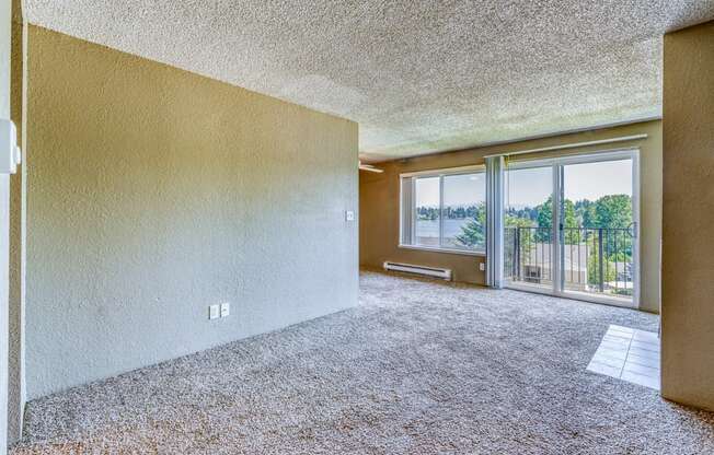 an empty living room with a balcony and a large window