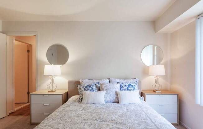 A bedroom with a bed, two nightstands, and two lamps.