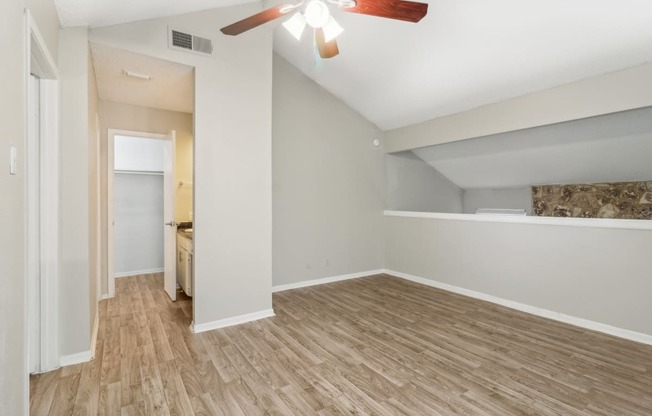 the bedroom of an apartment with a ceiling fan