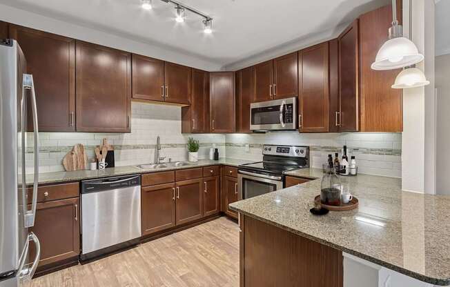 A kitchen with brown cabinets and a granite counter.