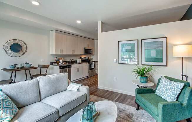 a living room and kitchen with a couch and chairs