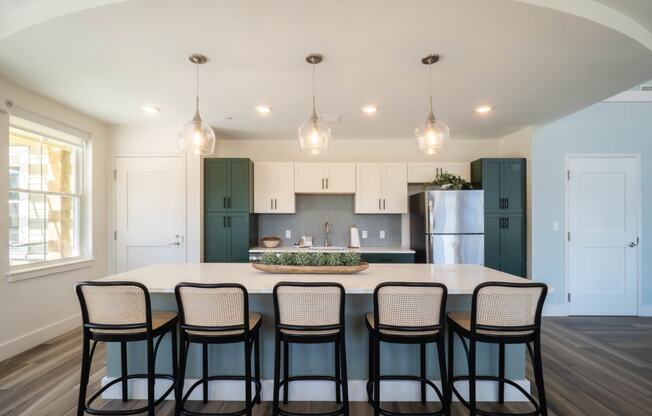 a clubroom kitchen with a large island and black chairs at Edgebrook Residences, Merrimack, NH