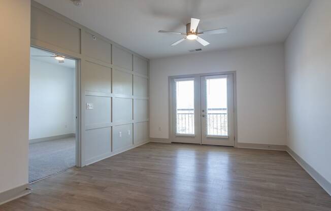 an empty room with white walls and a ceiling fan