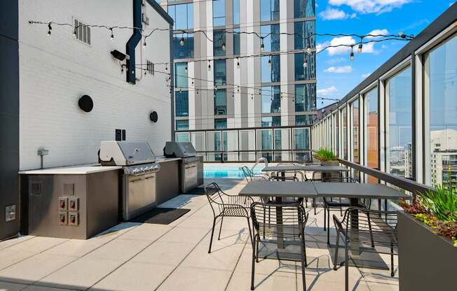 A patio with a table and chairs overlooking a pool.